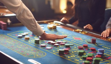 casino roulette table with players around 