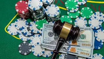 Casino chips, cards and money surrounding a gravel
