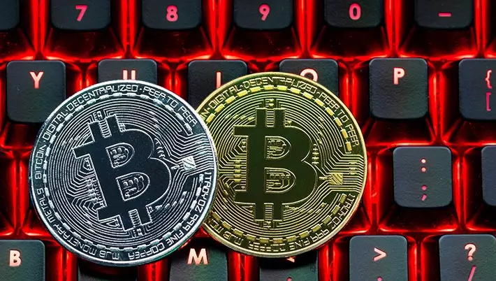 two bitcoin coins sitting on a computer keyboard