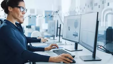 woman working with 2 computer screens 