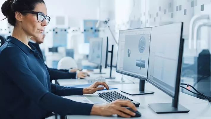 woman working with 2 computer screens 