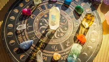 birthstone gems laid out on an astrological chart