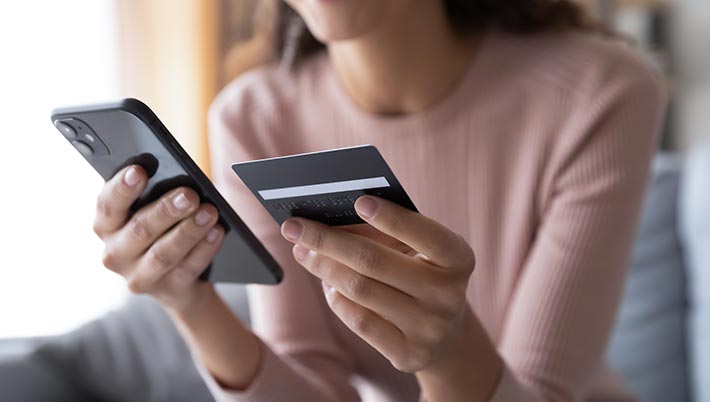 woman holding a smartphone and a credit card