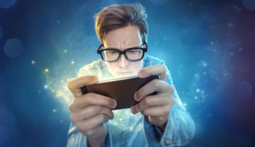 geeky guy frantically playing a game on a smartphone