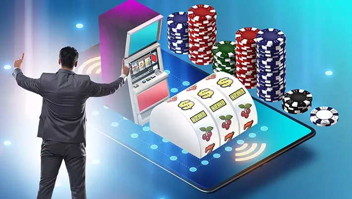 image of a man standing next to a huge mobile phone with a slot machine and casino chips 