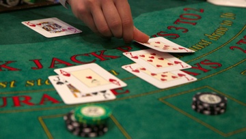 dealer putting cards down on a backjack table