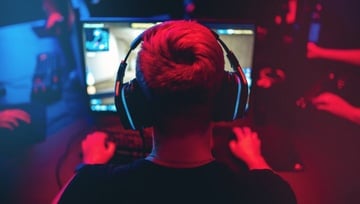 eports gamer sitting at his computer with a headset on