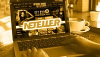 an open laptop with Grande Vegas Casino on the screen and the Neteller logo