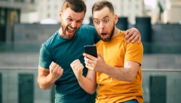 two guys looking at their phone happy they won a sports bet
