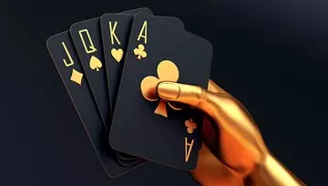 A gold hand holding a J, Q, K, A in black and gold cards