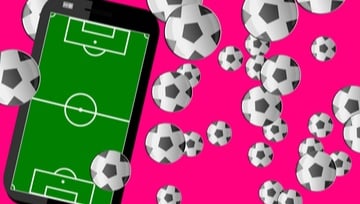 mobile phone with a soccer field on it and lots of soccer balls flying around on a pink background