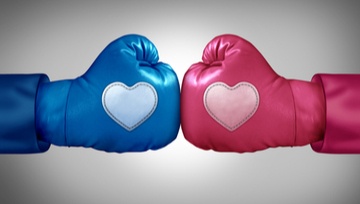 two opposing boxing gloves, one red, one blue each with a heart imprinted on the glove